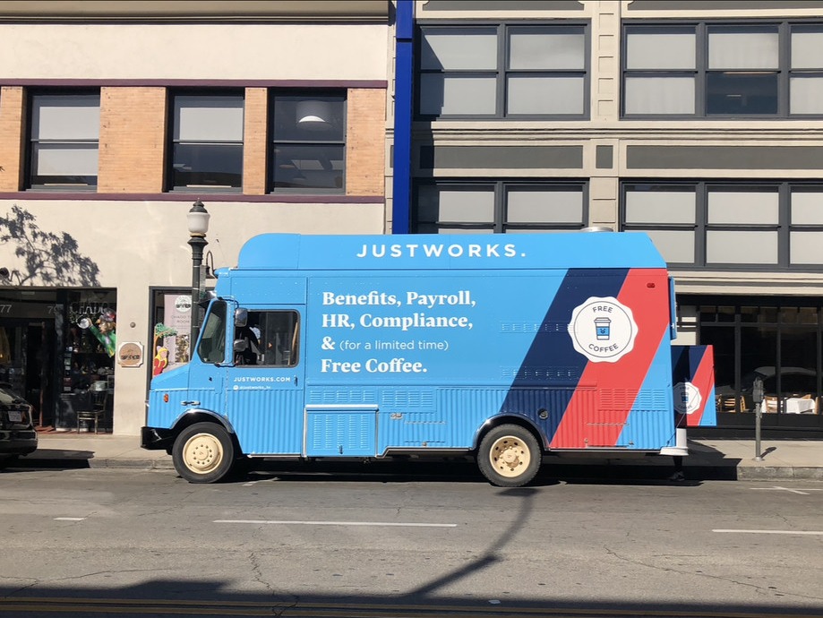 The Lime Truck Justworks brand activation — blue branded food truck wrap on a Los Angeles street with full Justworks brand identity, value prop messaging, and 'Free Coffee' activation hook